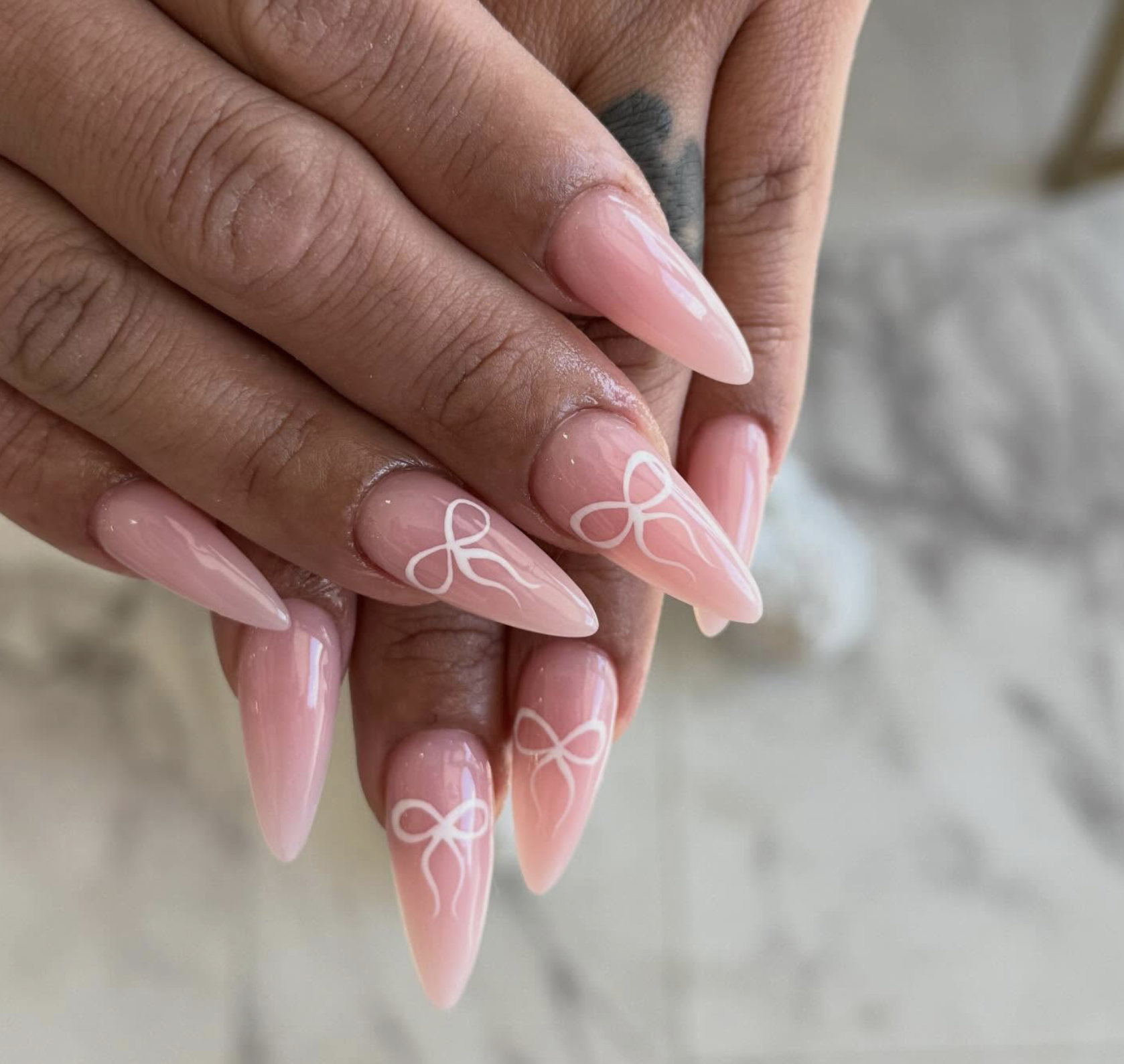 Pink stiletto nails with white bow design